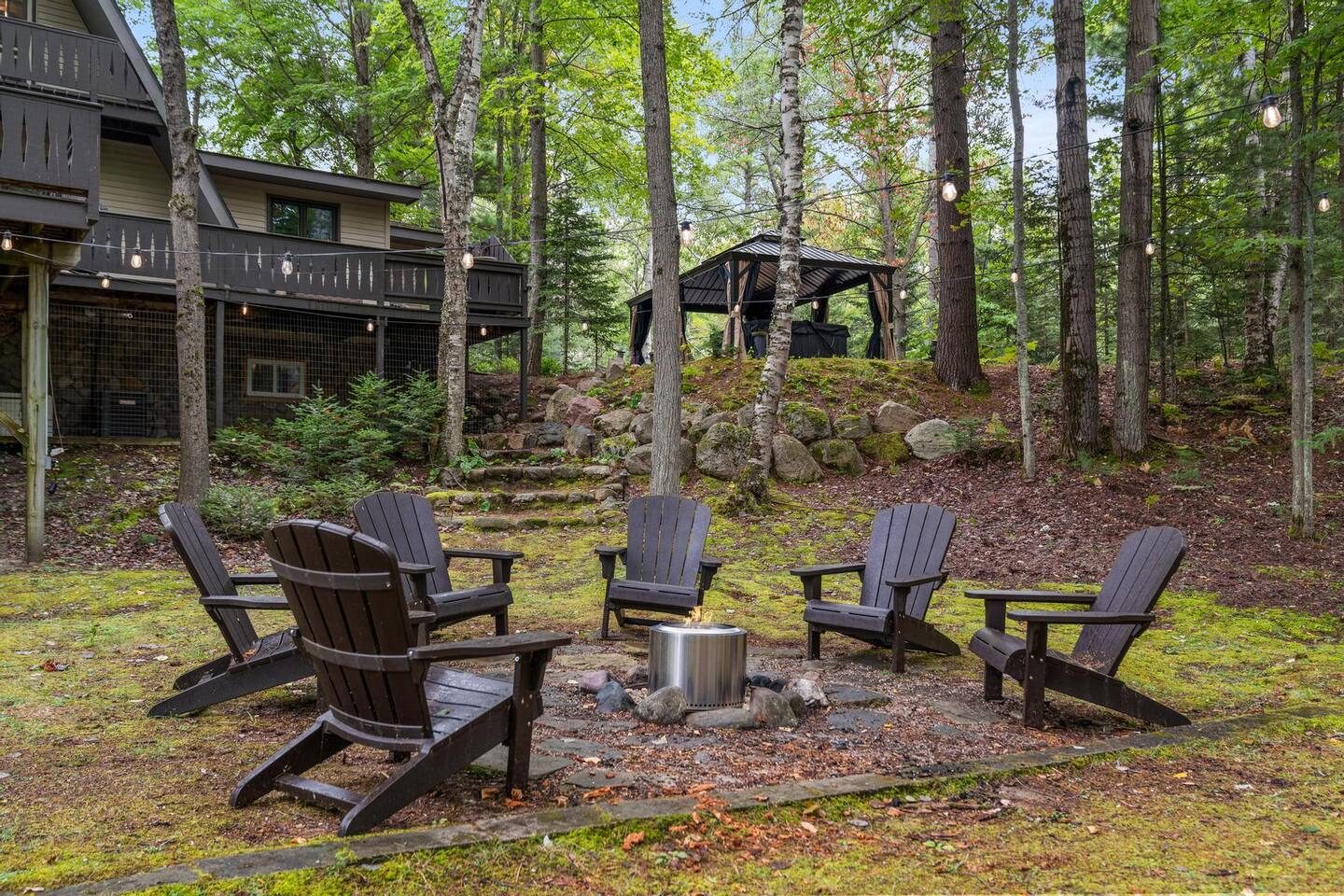 Fire pit with Adirondack chairs among the pines